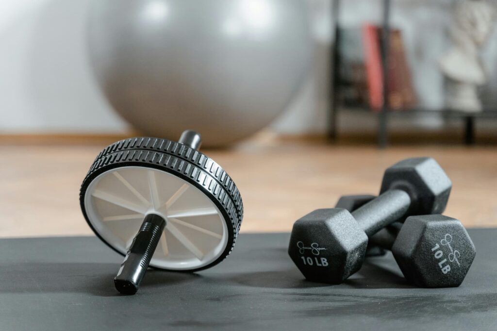 A minimalist home workout setup featuring essential equipment like an exercise mat, resistance bands, and dumbbells in a bright living room space.