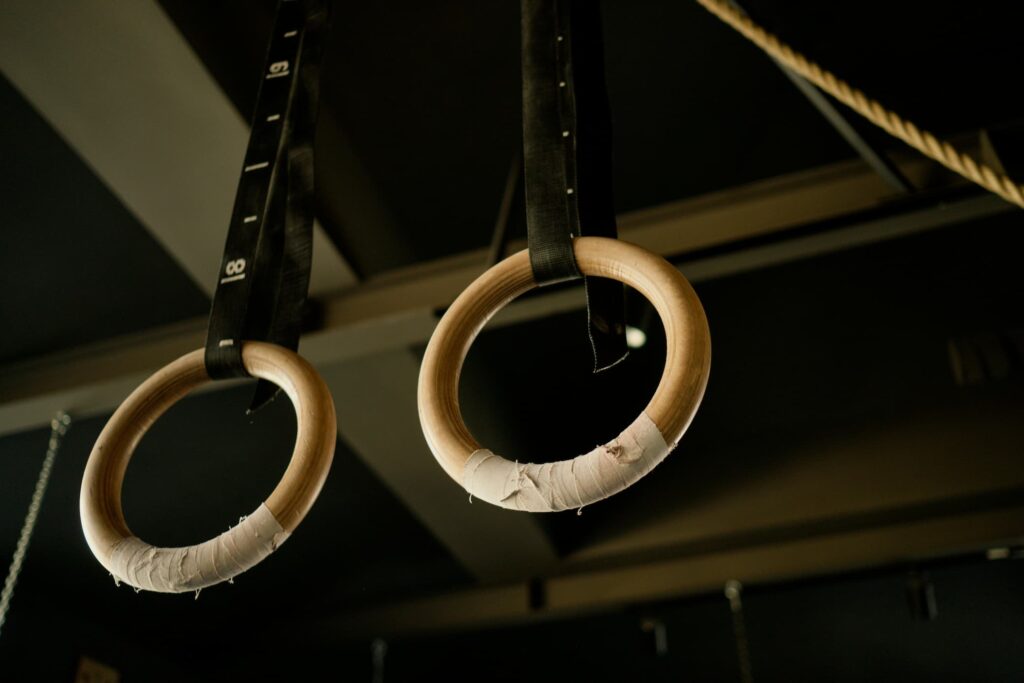 Professional wooden gymnastic rings with heavy duty numbered straps for easy height adjustment
