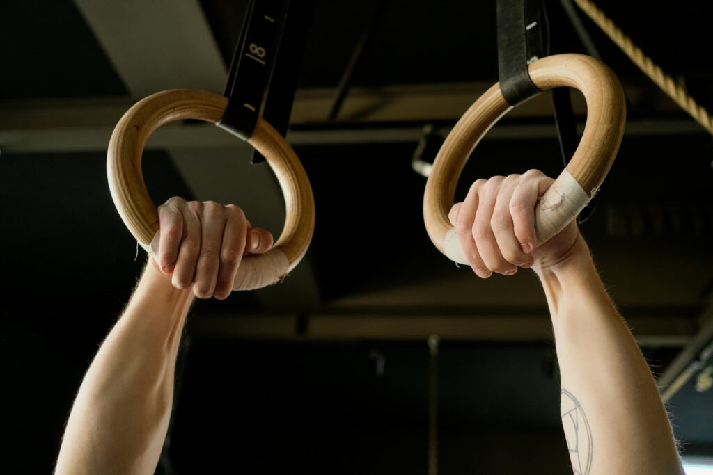 Wooden gymnastic rings hanging from a tree for outdoor bodyweight workout